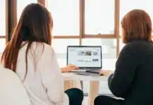 deux femmes travaillant sur un même ordinateur lors d'une réunion