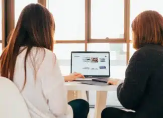 deux femmes travaillant sur un même ordinateur lors d'une réunion