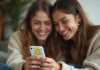 Deux amis souriants regardant un téléphone avec Snapchat